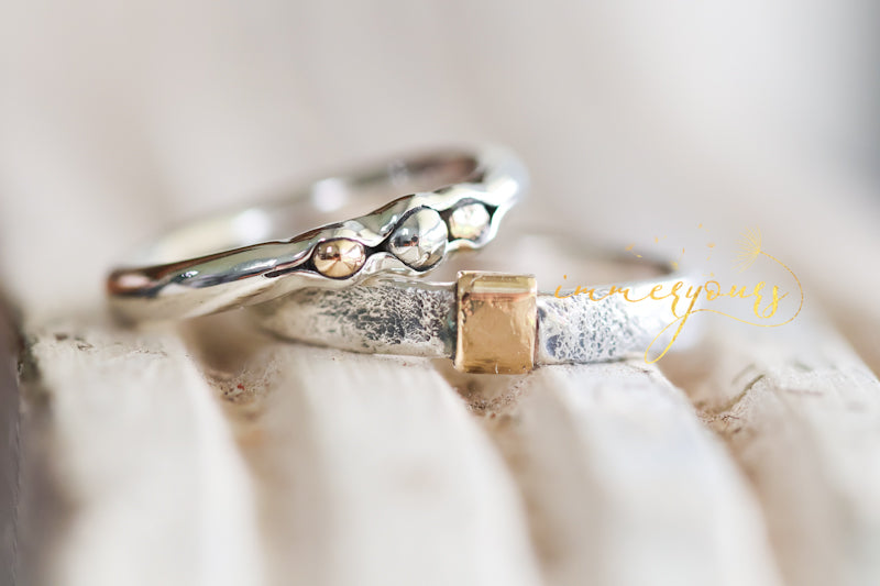 Close-up of a silver and gold ring on a textured surface
